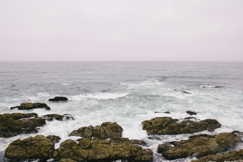 the ocean near the shore has rocks on it