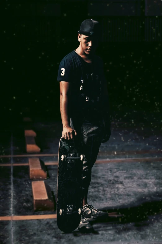 a young man with a black cap and some skate boards