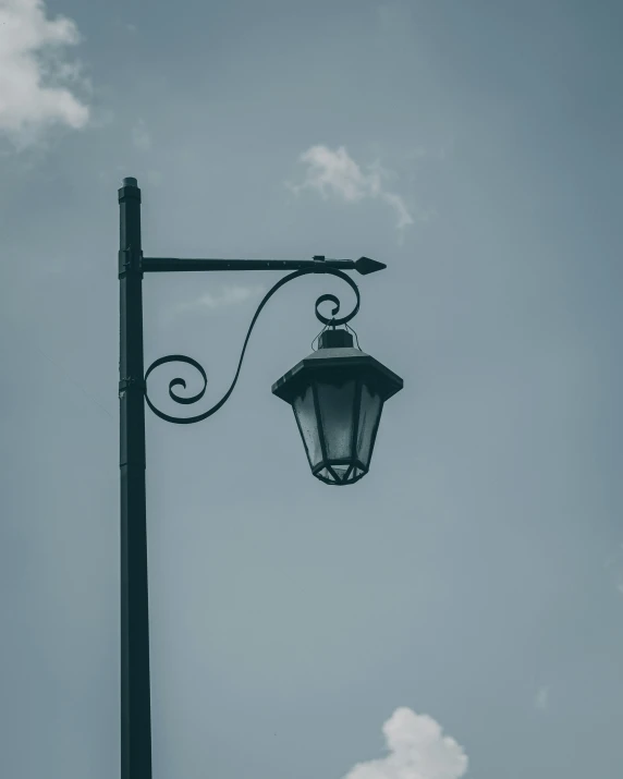 the black street light with its attached light fixture is looking up