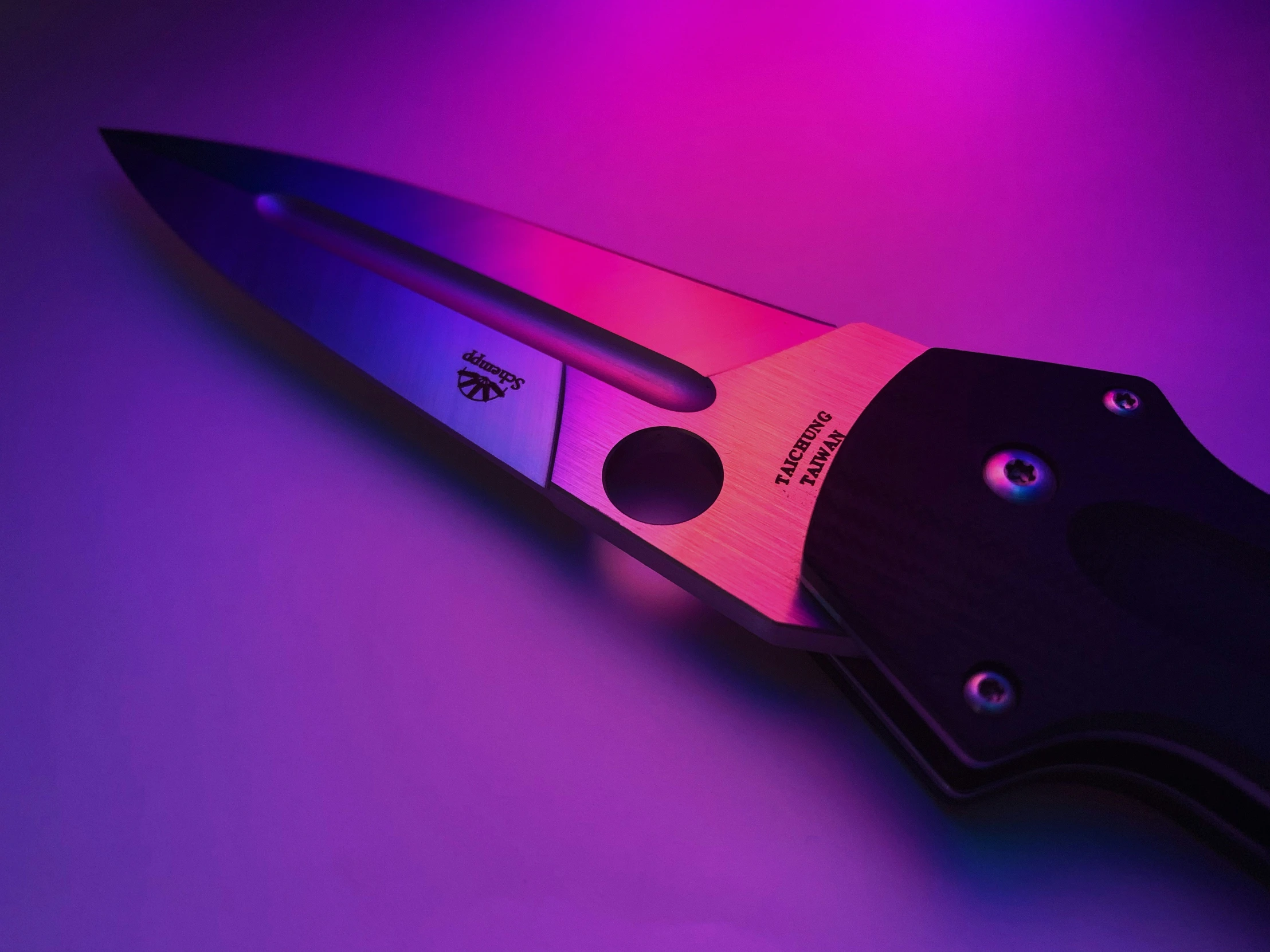 a knife in a dark purple hue with black handles