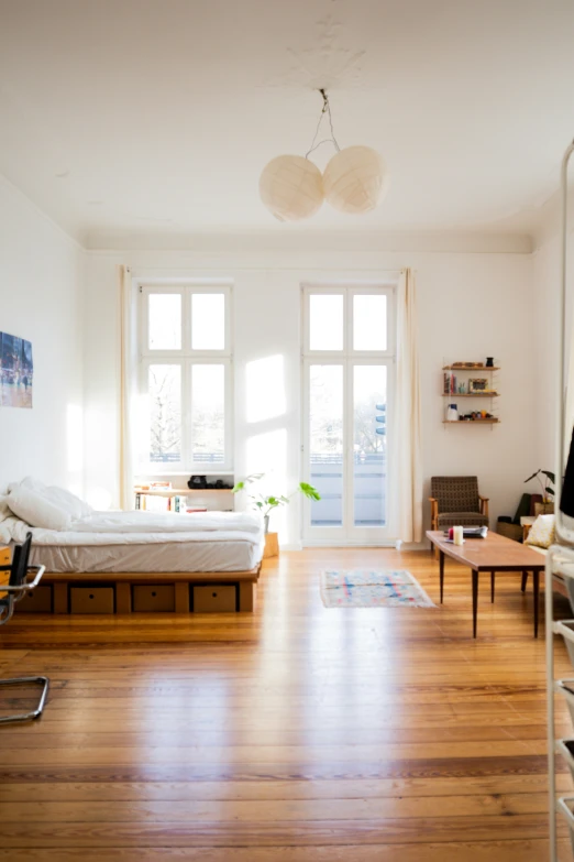 a living area with a bed, two tables, and a couch