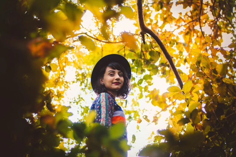 a woman is standing among many leaves