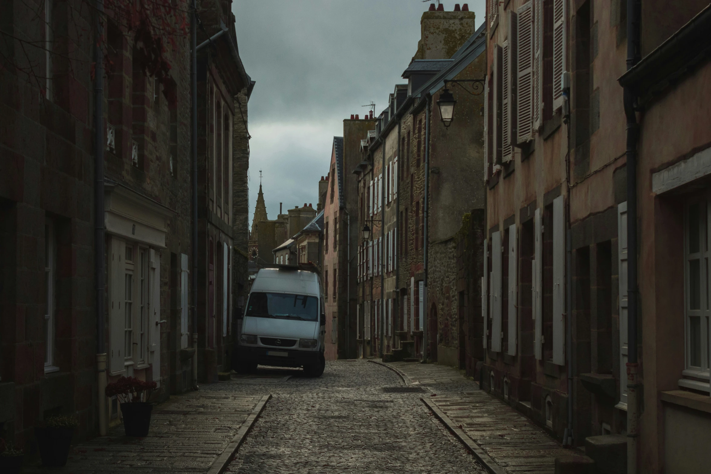 a van parked along side a street next to some buildings