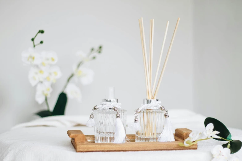 two bottles and two sticks on a tray