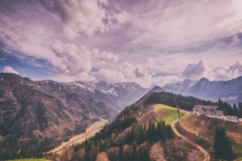 a grassy hill with mountains in the background