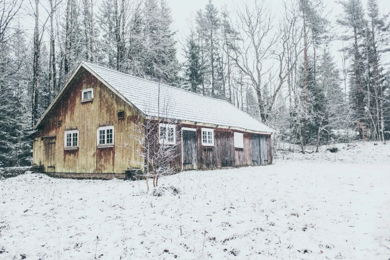 a small barn is on the snowy ground