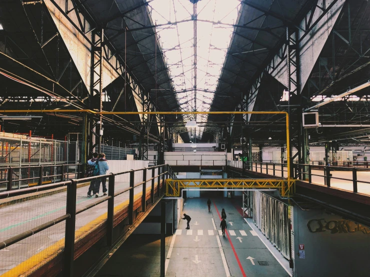 a long empty train station with people on the platform