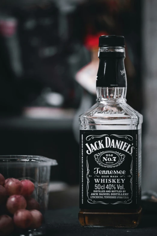 a bottle of jack daniels old spice whiskey next to a glass of gs