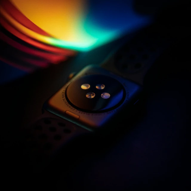 a remote control in front of a multi colored lamp