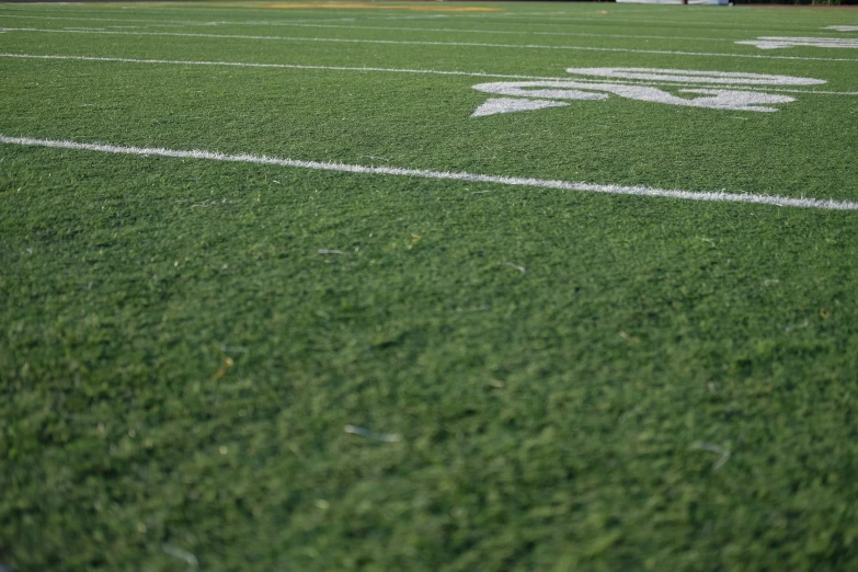 an empty field with a football and two football goal posts