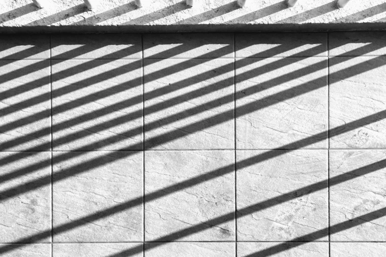 the shadow of a wall on cement with stone blocks