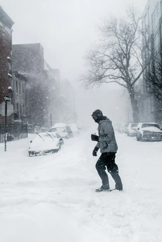 a man is walking through the snow on his snowboard