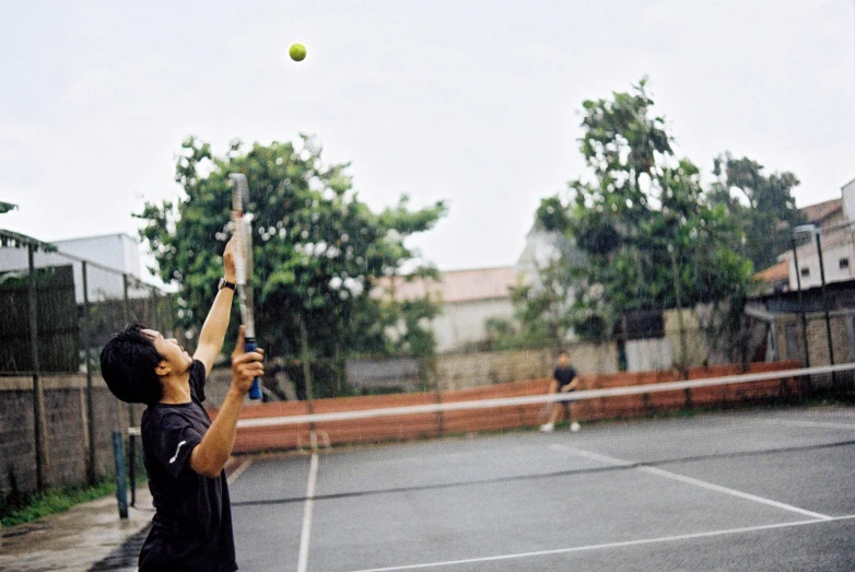 a young person swinging a tennis racquet at a ball