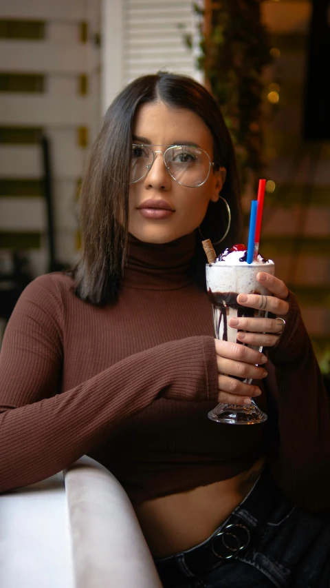 a woman holding an ice cream drink next to her stomach