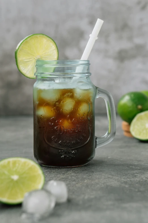 a mug with a straw and lime is on the counter