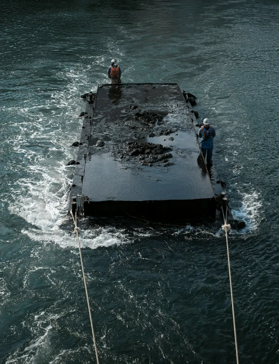 two men standing on a floating platform in the water