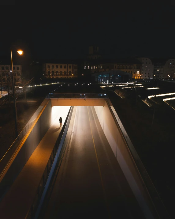 a person standing on a long walkway in the dark