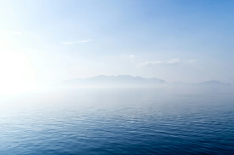a large body of water sitting in the middle of a blue sky