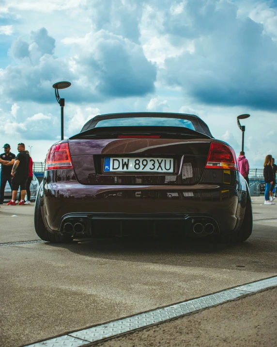 the rear view of a brown sports car on the road