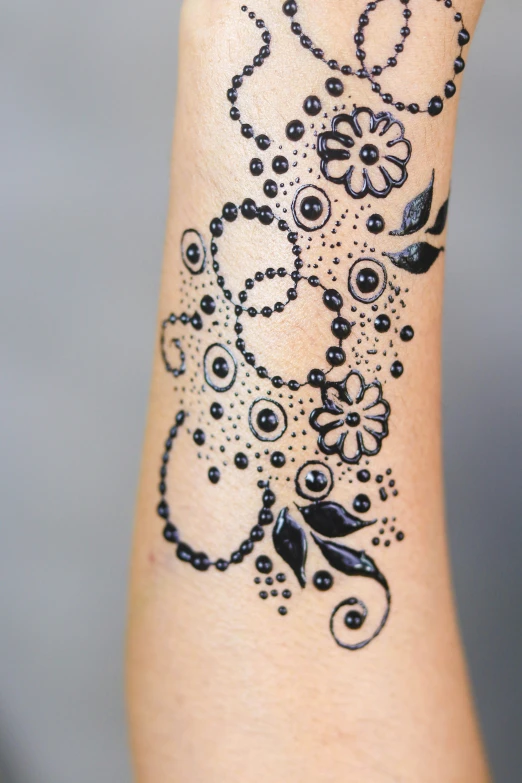 a black and white picture shows a flower tattoo on a female leg