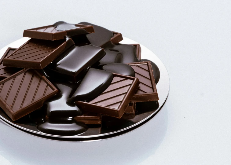 chocolate in chocolate bar on white plate on grey background