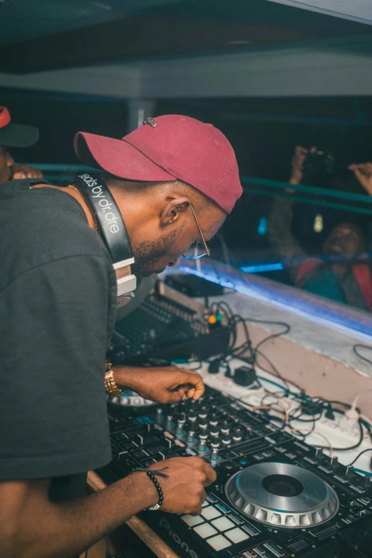 a man sitting at a dj's decks with headphones on