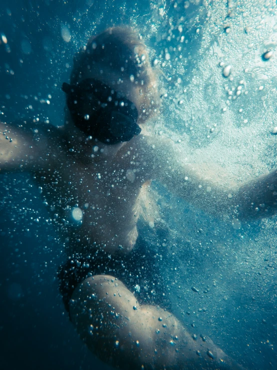 a woman underwater with bubbles covering her face