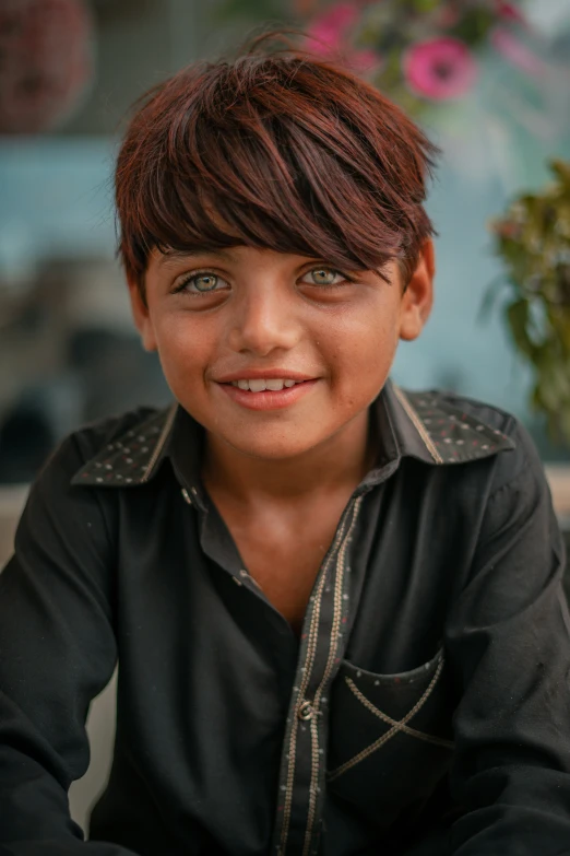 a boy with dark hair smiles as he sits for a pograph