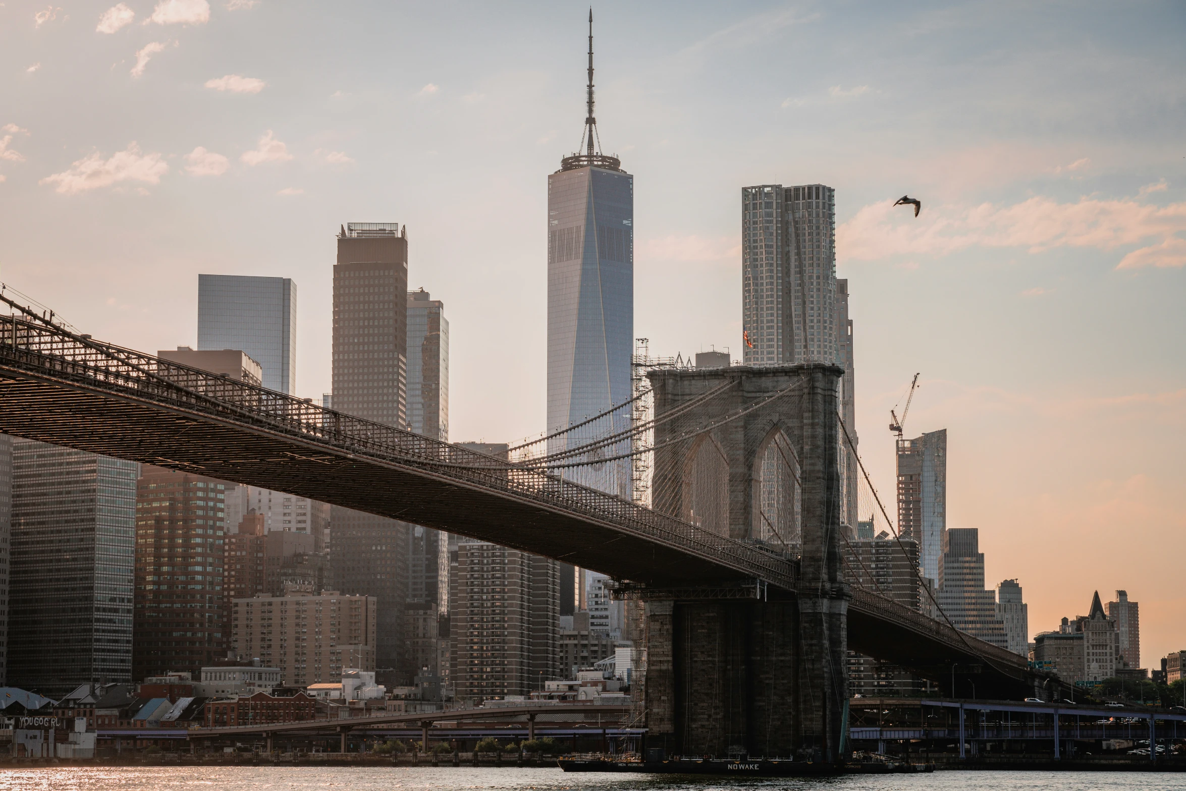 a bridge across the water with city in background