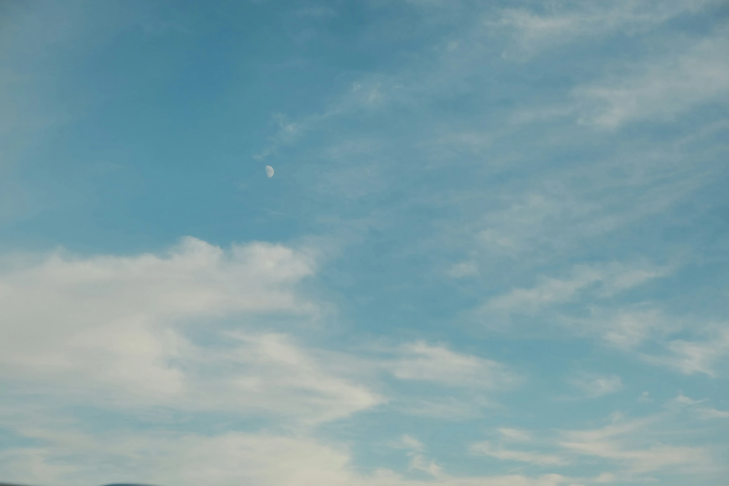 an airplane in the sky with blue clouds