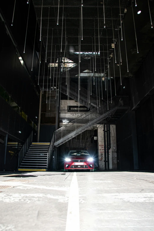 a car parked on the side of the road at night in a tunnel with a staircase