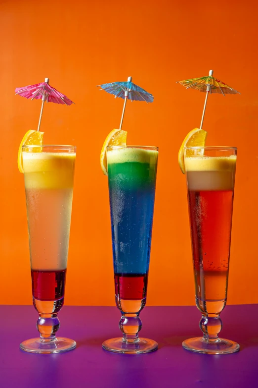 three different types of drinks with umbrellas on top of each