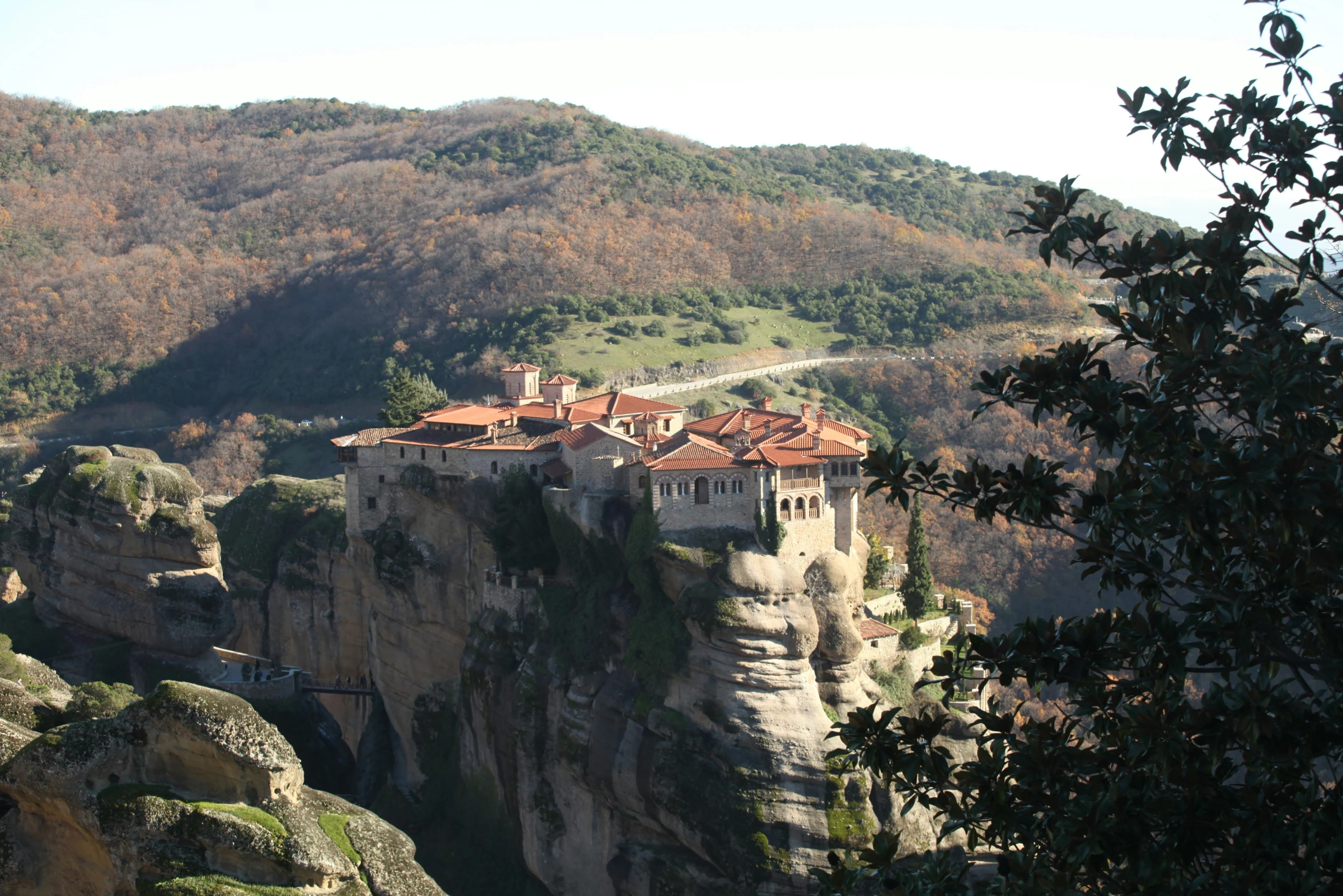 a small village is shown atop a cliff in front of a mountain