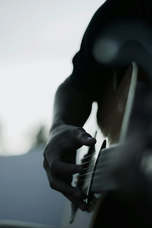 a close up image of a person playing guitar