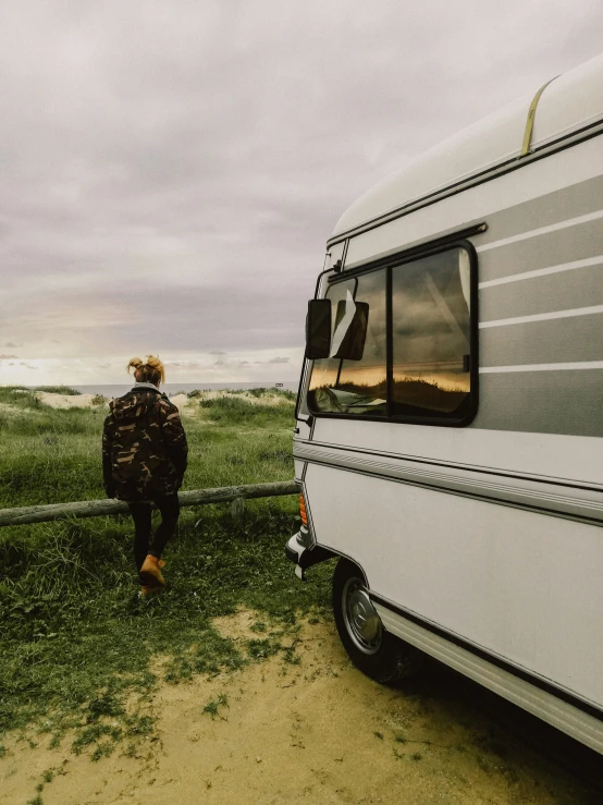 the man in plaid walks beside a trailer that is parked