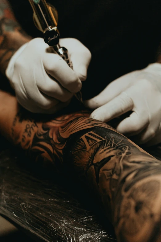 the tattooed hand of a man who is holding an ink pen