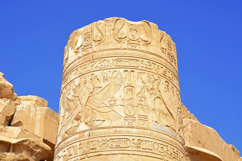 a tall, carved stone pillar in front of some smaller stone blocks