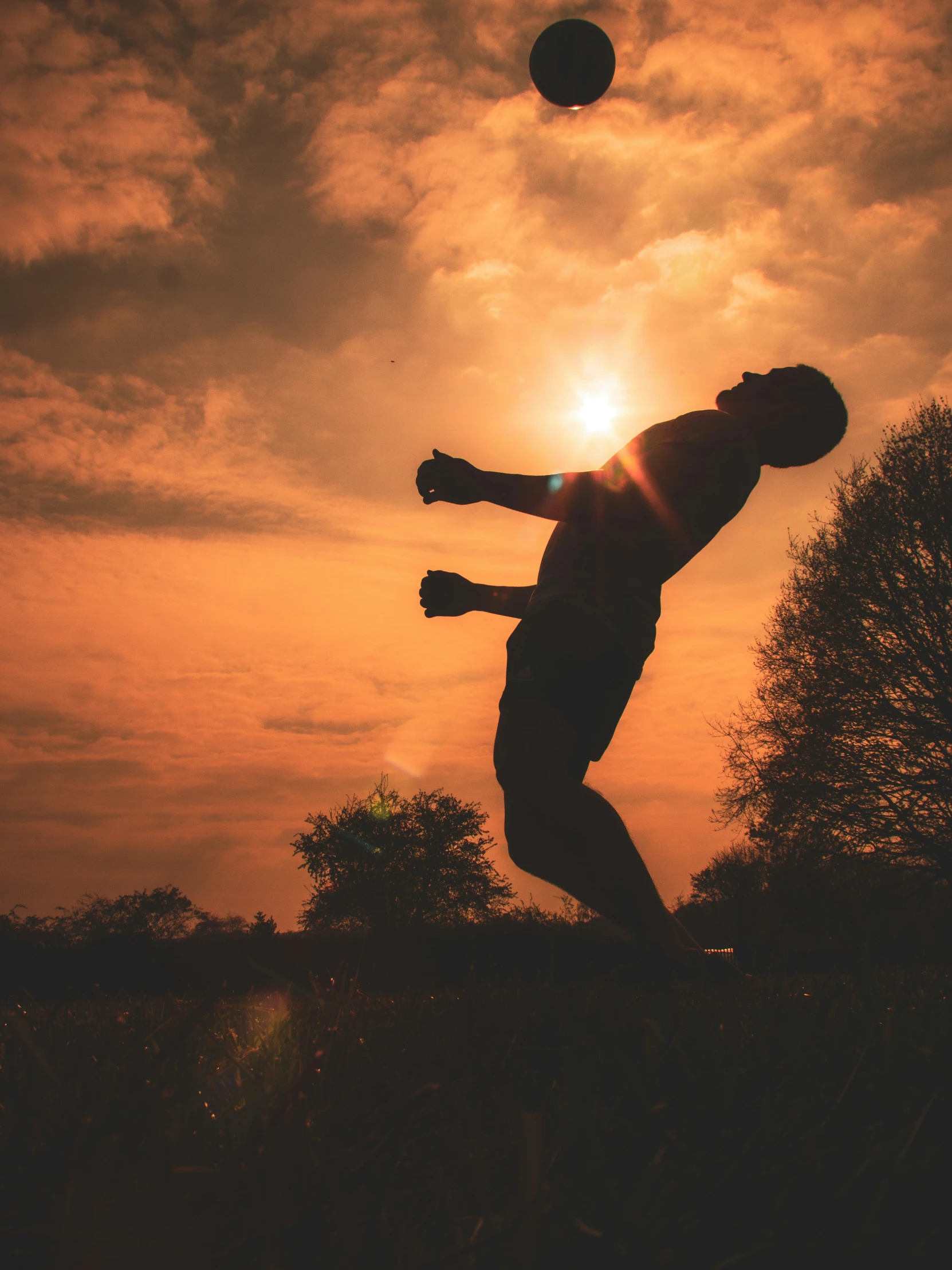 a person reaching for a soccer ball in the air