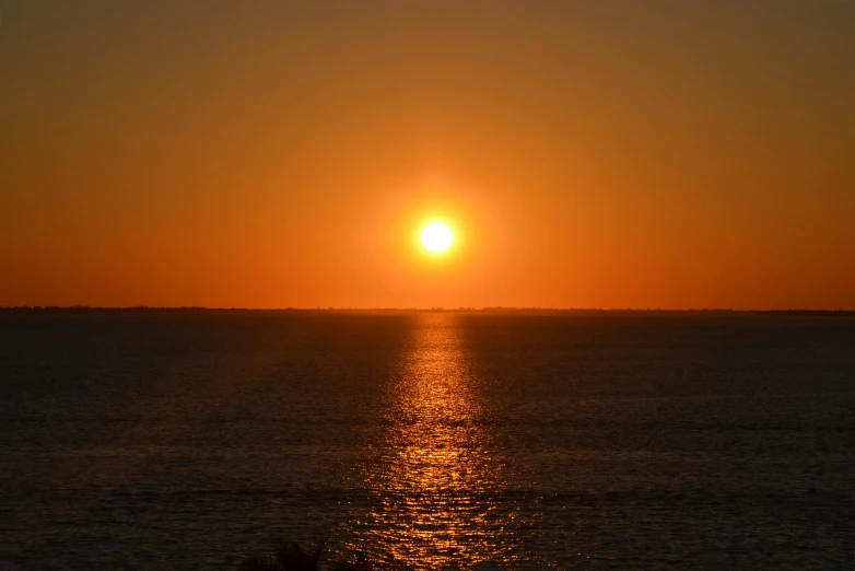 a boat on the water as the sun goes down