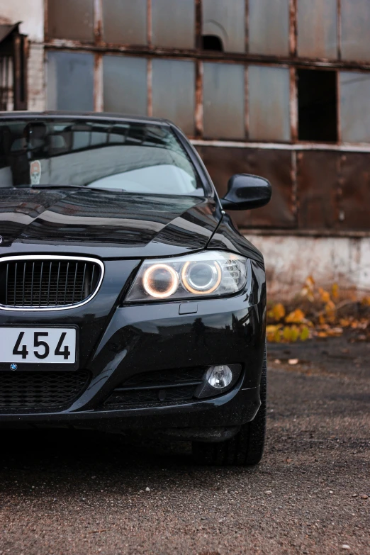 black bmw car parked on a road with no people