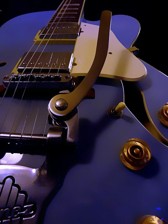 a close up of a blue guitar with a light on