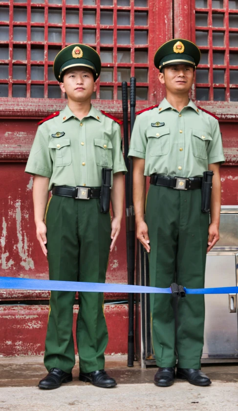 two policemen standing next to each other in front of a red building