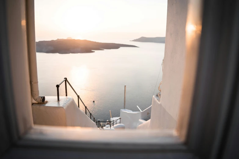 the sun shining on the water is seen from an apartment window