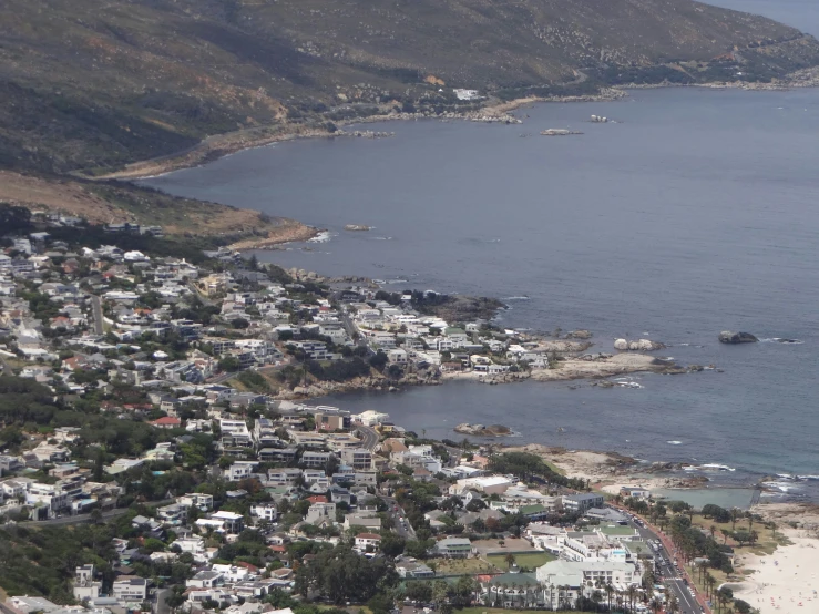 a beach next to the ocean surrounded by a lot of buildings