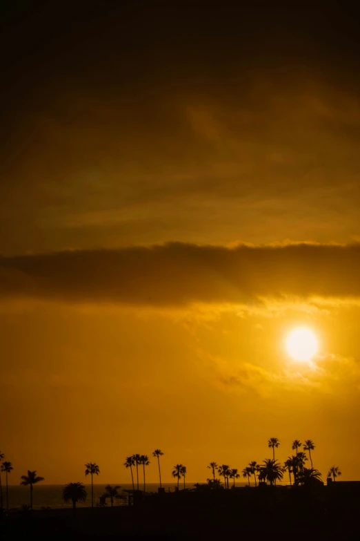 a plane flying through a cloudy sky at sunset