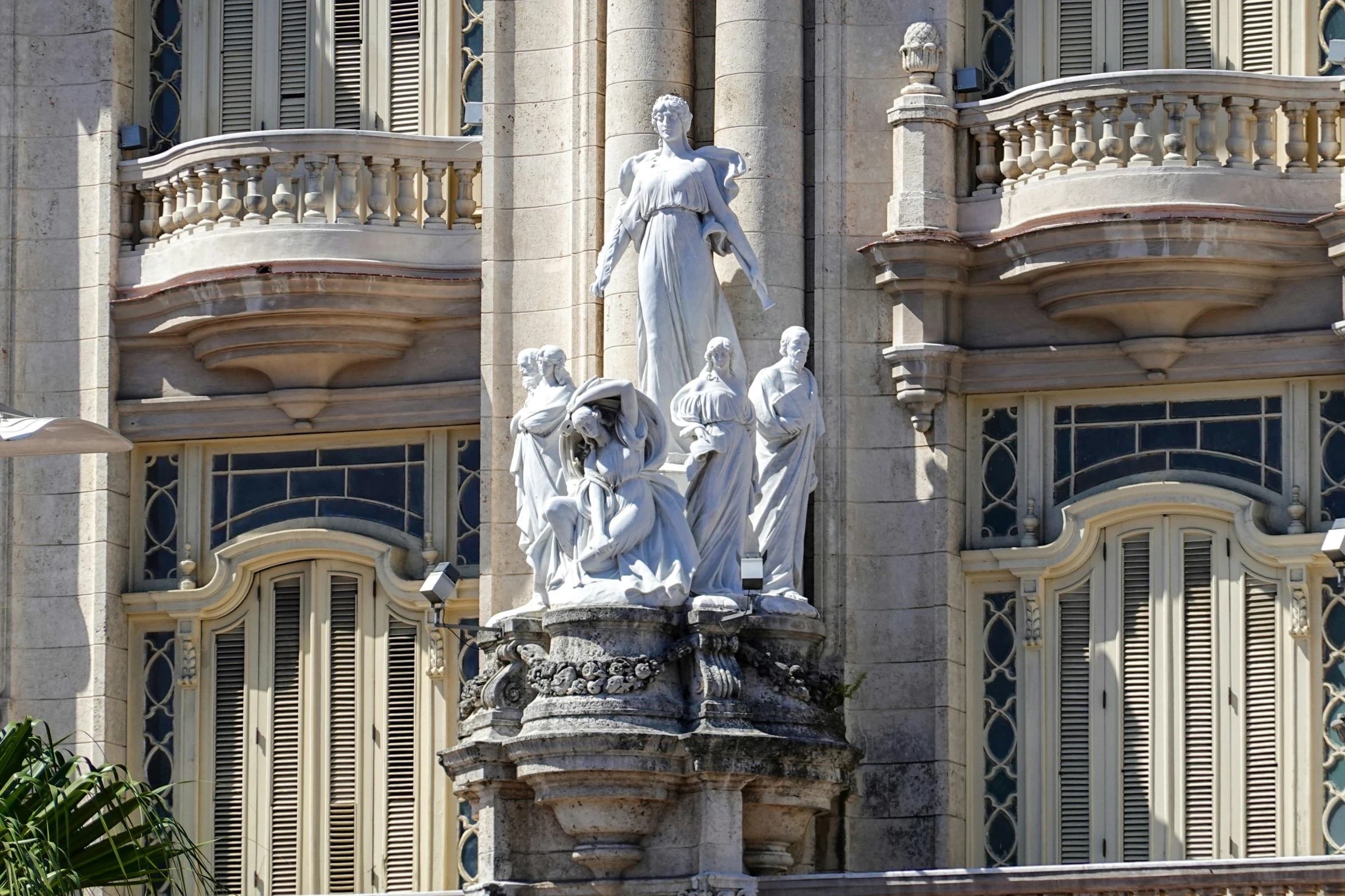 a statue on a pillar with windows in the background