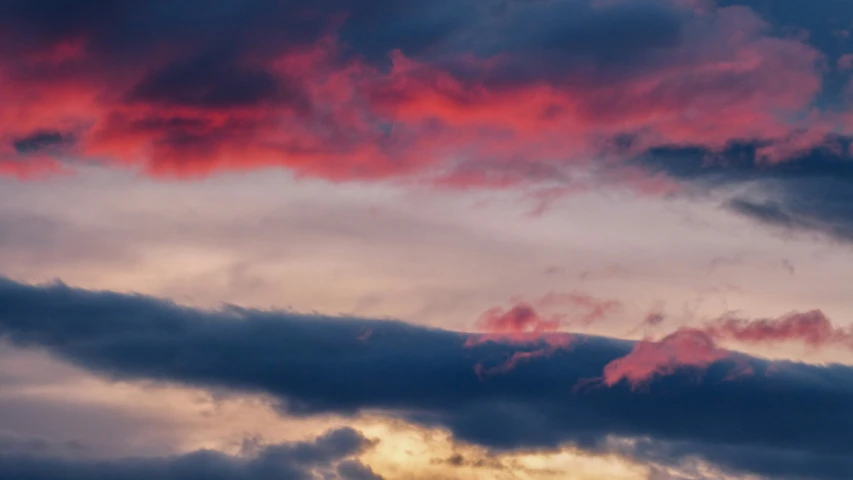 the clouds are lit up in pink and blue