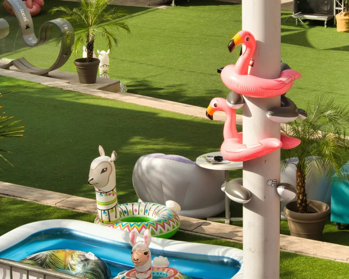 an animal themed pool with flamingos and a horse in the background