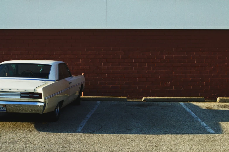 a car parked next to a brick wall in a parking lot