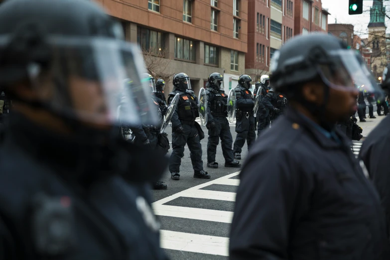 several men wearing riot gear standing in a street